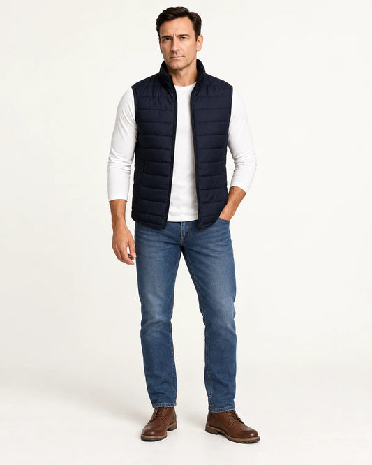 Rowan men's quilted puffer vest in navy with stand collar, front view worn open over a white long-sleeve tee