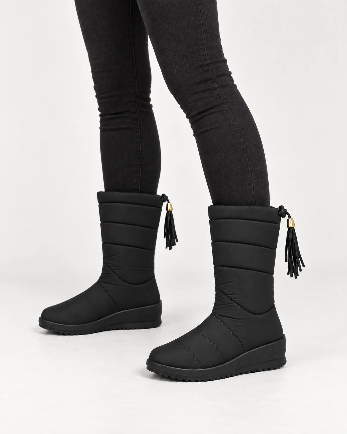Sigrid women's quilted mid-calf winter boots in Black, close-up of the quilted shaft, tassel and wedge sole