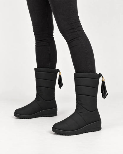 Sigrid women's quilted mid-calf winter boots in Black, close-up of the quilted shaft, tassel and wedge sole