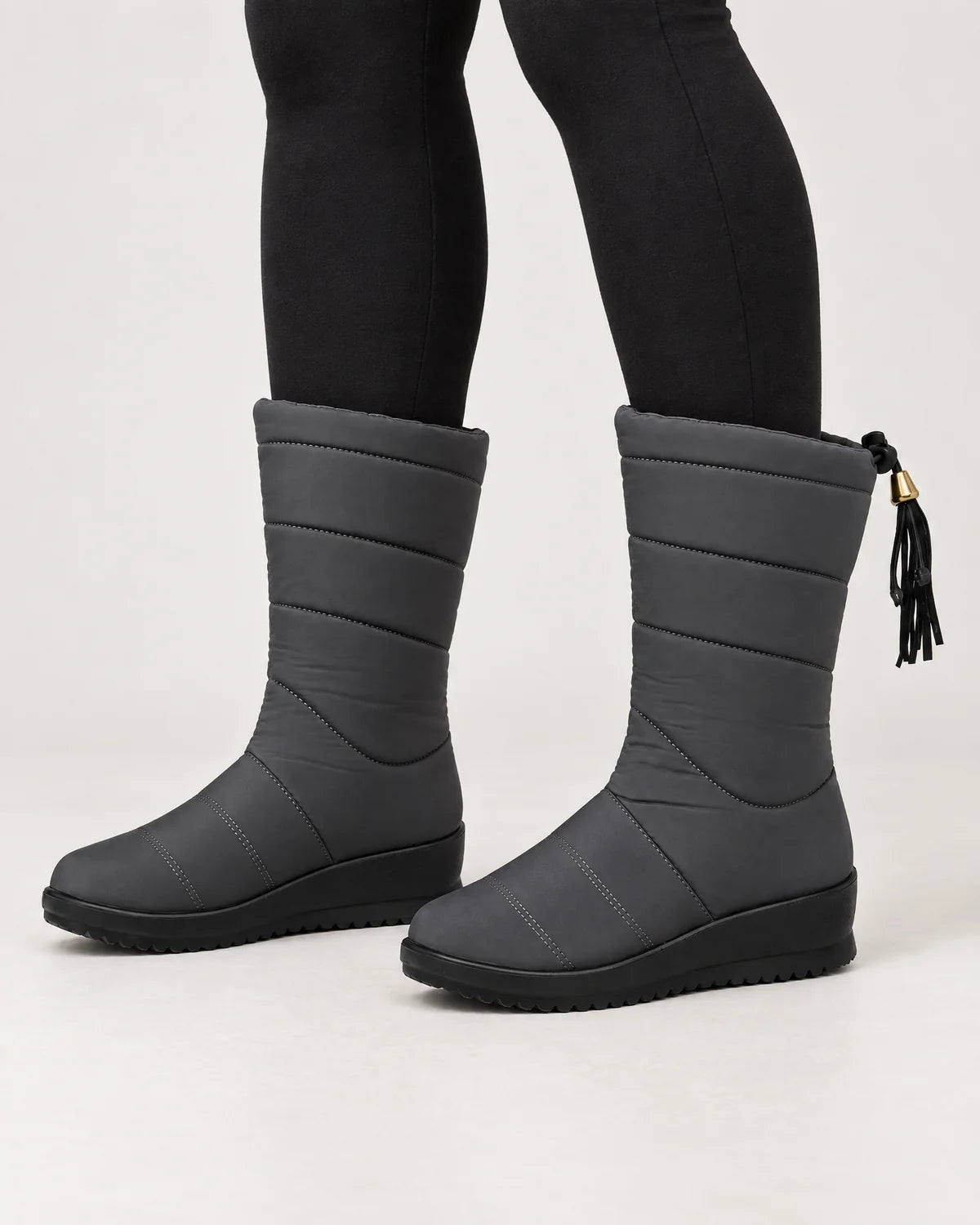 Sigrid women's quilted mid-calf winter boots with tassel tie in Gray, worn with black leggings