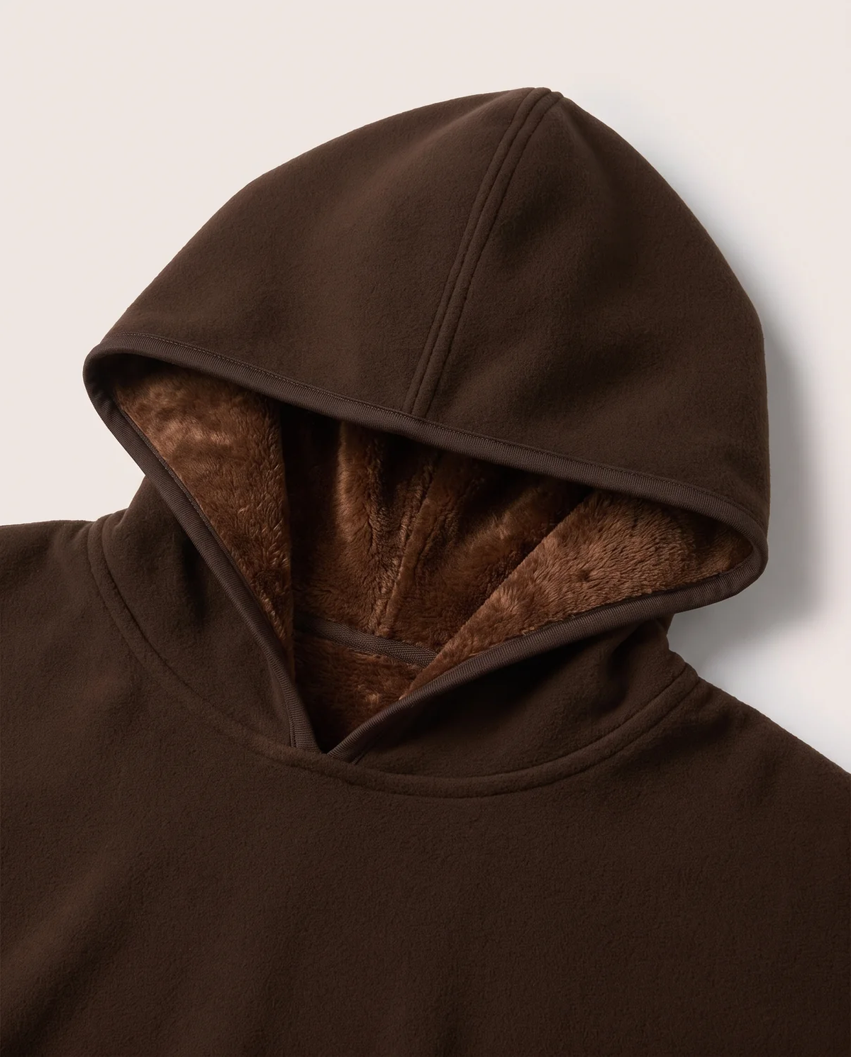 Otis hooded blanket in espresso draped over a sofa arm with the hood and plush lining visible