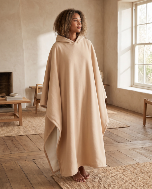 Woman wearing the Alba sherpa-lined hooded blanket in cognac with the cream lining visible, front view